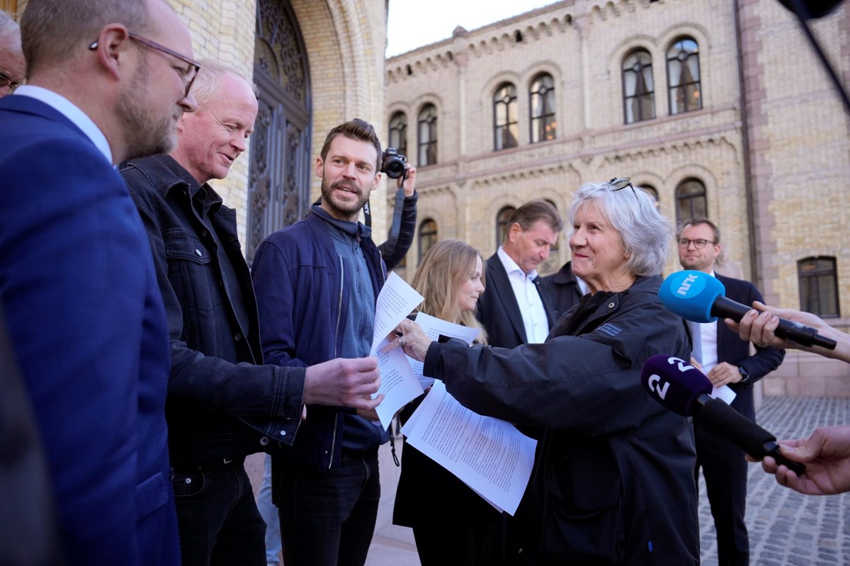 Tidligere LO-leder Gerd-Liv Valla deler ut et skriv fra alternativ energikommisjon til Lars Haltbrekken (SV) og Bjørnar Moxnes (R) utenfor Stortinget i forbindelse med det ekstraordinære strømmøtet i september.
